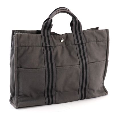 sac fourre-tout en toile grise avec des fermetures éclair noires sur fond blanc