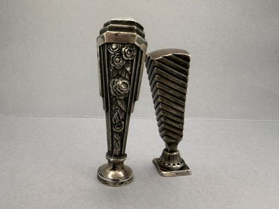 two silver vases sitting next to each other on a table