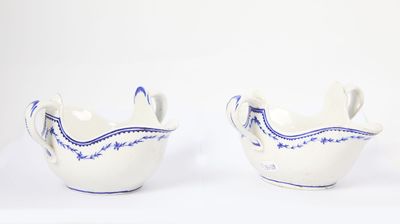 two white bowls with blue designs on them on a white surface