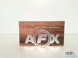 a close up of a wooden business card with a logo on it