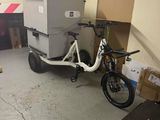 un vélo auquel est attelée une remorque, dans un garage