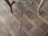 a small table with a wooden top on a wooden floor
