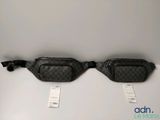 two black and white fanny bags sitting on top of a table