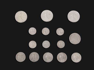 a close up of a bunch of silver coins on a black background