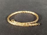 a close up of a gold bracelet on a black surface