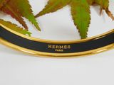 a black and gold bracelet with a leaf on it