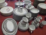 de nombreuses assiettes et tasses posées sur une table recouverte d'une nappe rouge
