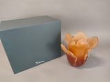 a glass vase with a flower inside of it next to a box