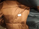 the jacket is brown and black with a white label on it