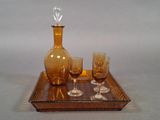 Les bouteilles et les verres sont posés sur un plateau sur lequel se trouve une carafe en verre.