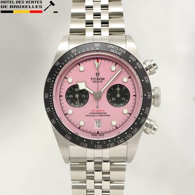 a close up of a watch with a pink dial