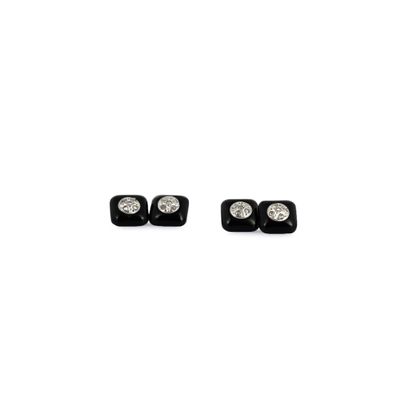 une paire de boucles d'oreilles à clous en diamant noir et blanc sur fond blanc