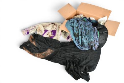 un tas de vêtements et une boîte posés sur une surface blanche