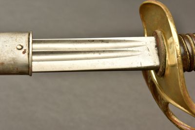 a close up of a sword with a gold handle