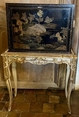 une table noire et dorée surmontée d'un miroir