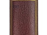 un vieux livre à la couverture brune posé sur une surface blanche