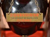 a bottle of cognac on display in a glass case
