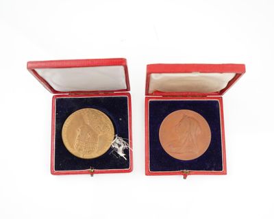 deux médailles d'or dans un coffret rouge posé sur un fond blanc