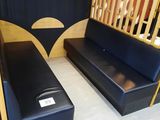 un canapé noir et un banc en bois dans une pièce