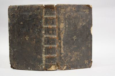 an old book sitting on top of a white surface