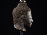 a bronze head of a person wearing a helmet on a stand