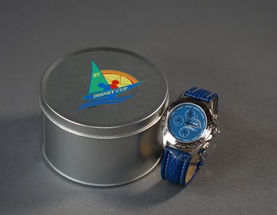 a small tin with a watch on it next to a small tin with a watch inside