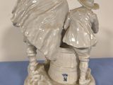 a figurine of two people standing on a barrel