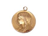 Gros plan sur une médaille d'or portant le visage d'une femme