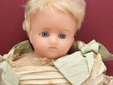 a small doll with blonde hair and blue eyes