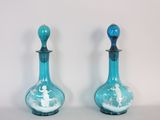 deux vases en verre bleu ornés de motifs blancs