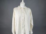 une chemise blanche posée sur un mannequin, devant un fond gris
