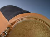 a close up of a tan and black bag on a table