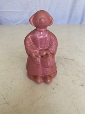 figurine en céramique rose représentant une femme tenant un panier