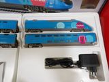 three blue trains sitting on display in a box