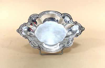 un plateau en argent avec un centre en verre posé sur une table