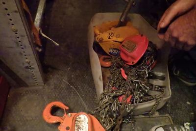 un homme qui travaille sur des chaînes à l'aide d'un marteau