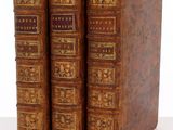 deux vieux livres sont posés côte à côte sur une surface blanche