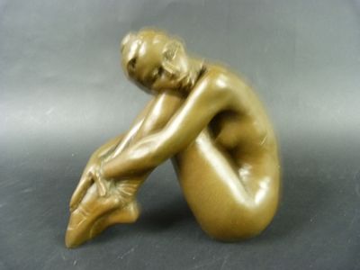statue en bronze représentant une femme assise à genoux, les mains posées sur les genoux