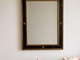 une photo d'un salon avec un canapé et un miroir accroché au mur