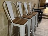 quatre tabourets alignés contre un mur dans un restaurant