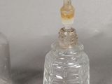 a small glass bottle with a glass stopper next to it
