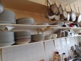 beaucoup d'assiettes et de casseroles sur les étagères de la cuisine