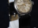 an old watch on a stand on a black background