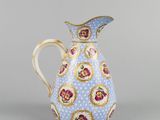 a blue and white pitcher with a floral design on it