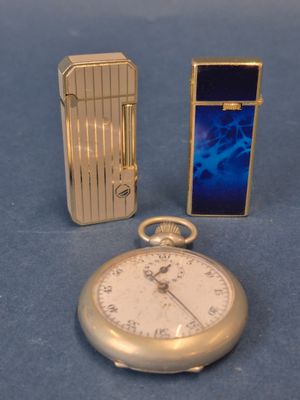 un briquet et une montre de poche posés l'un à côté de l'autre