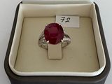 a ring in a box that has a red stone in it