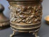 a gold cup sitting on a table next to a candle holder