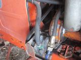 a close up of an orange tractor with a hose attached to it