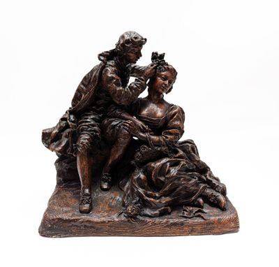 une statue en bronze représentant un homme et une femme assis sur un rocher