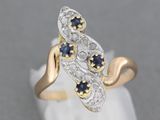 un gros plan sur une bague en or et en argent sertie de saphirs bleus